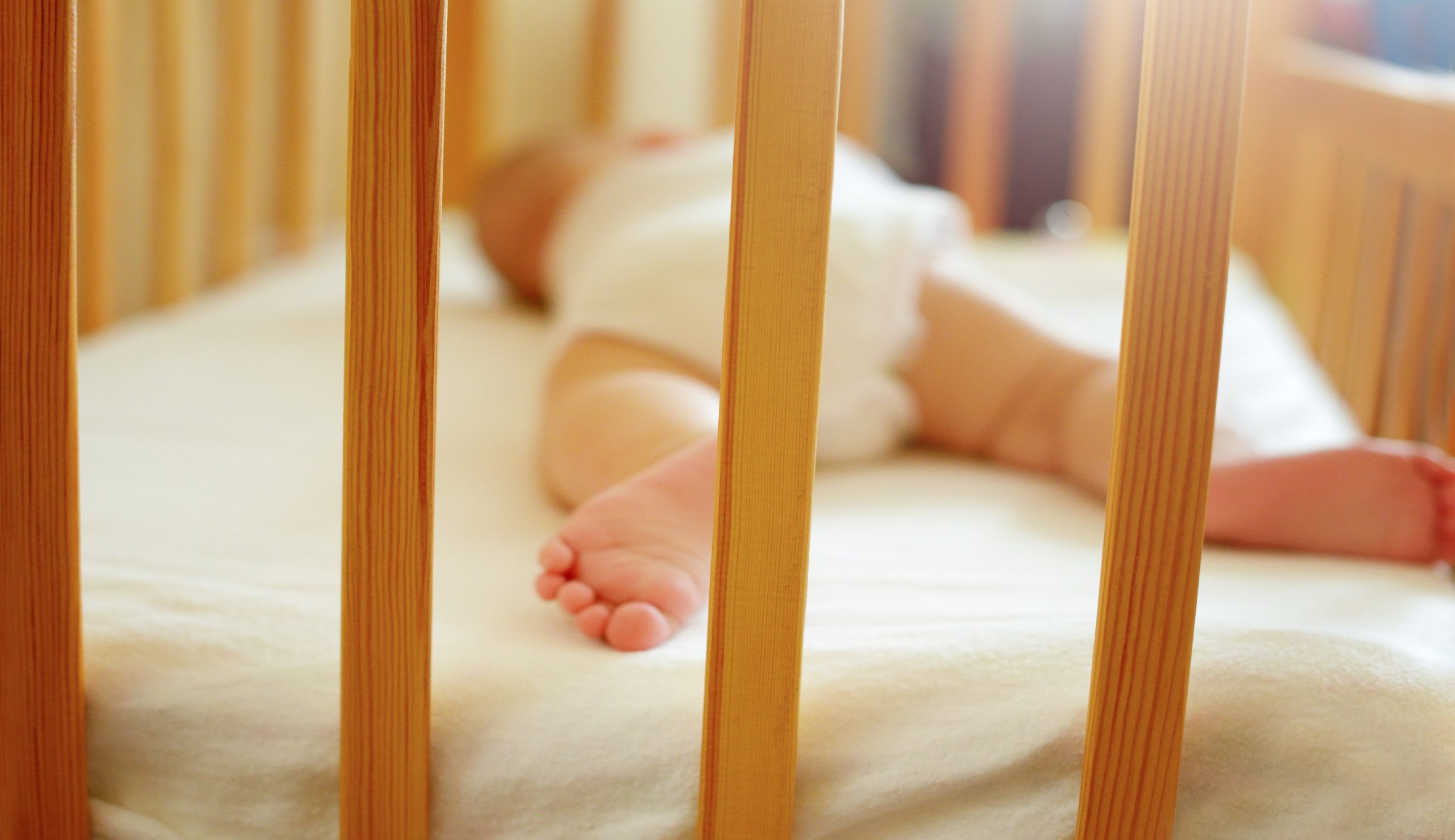 Infant baby is sleeping in his crib. Importance of sleep for babies. Sleep mode babies 5 months
