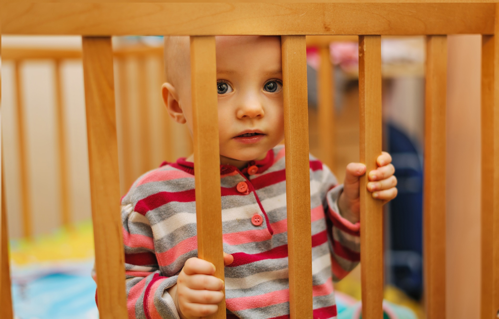 pretty child sitting in a crib